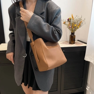 Brown leather tote bag with a soft silhouette and wide shoulder strap for daily commuting