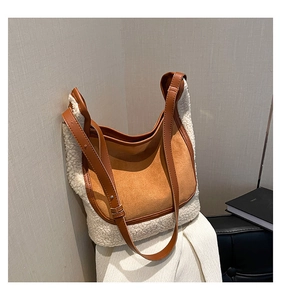 Detail of plush tote bag with white faux shearling and brown suede paneling textures