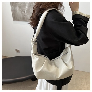 Detail of off-white lychee texture leather shoulder bag with knotted strap design