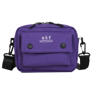 Detail view of the purple canvas crossbody bag showing buckle texture and fabric weave