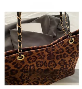 Détail du sac cabas léopard avec une chaîne en métal doré et une bandoulière en cuir