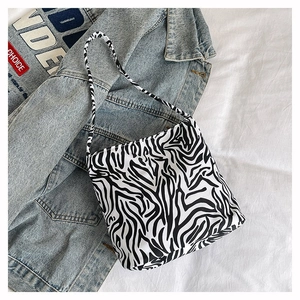 Vue de dessus d'un sac cabas à imprimé zèbre posé sur une veste en jean et tissu