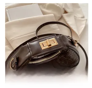 Detail of dark brown woven shoulder bag featuring a polished gold metal twist lock