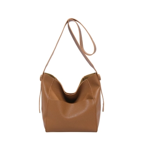 Caramel lychee grain leather tote bag in a minimalist bucket shape with long shoulder straps