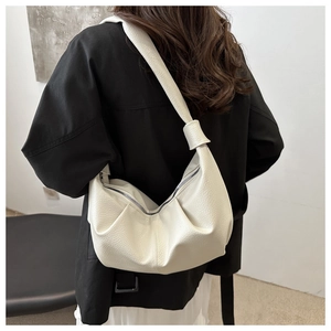 Detailed back view of a white pebble leather hobo bag on a model in a black blazer