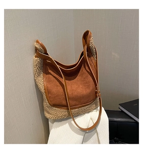 Detail of hobo tote bag featuring beige faux shearling and brown suede patchwork design