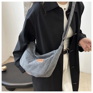 Detail of gray corduroy crossbody bag texture and brown Fashion patch label