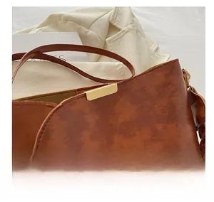 Gros plan d'un sac seau marron vintage en cuir marbré avec détails en métal doré