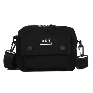 Close-up of black canvas crossbody bag with DČÝ embroidery and metal buckles