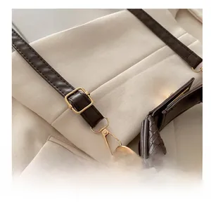 Detail of crocodile embossed leather strap with gold metal buckle and lobster clasp hook