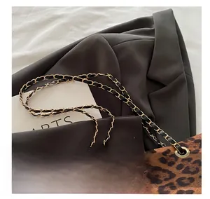 Détail du sac cabas léopard avec bandoulière en chaîne dorée et cuir noir entrelacés