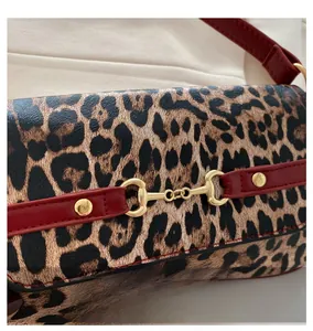 Close-up of leopard print shoulder bag with gold horsebit buckle and red leather trim