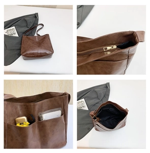 Close-up details of brown faux leather tote bag with large side pockets and metal zipper