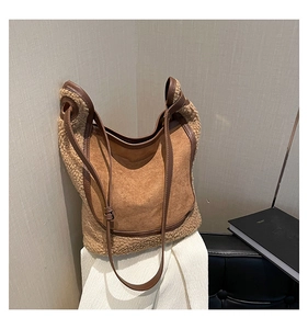 Close-up of brown suede and shearling tote bag showing contrast textures and leather strap