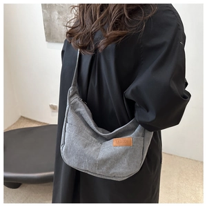 Detail view of the gray corduroy crossbody bag with adjustable wide shoulder strap