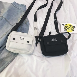 Flat lay of Japanese-style canvas crossbody bags in black and white with adjustable straps
