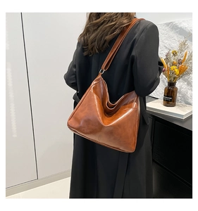 Detail of vintage brown large capacity tote bag with side pocket shown on a model