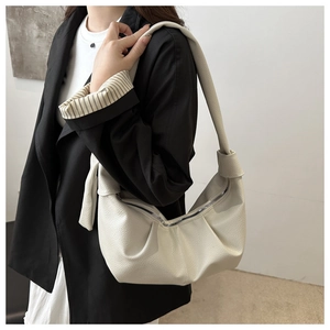 Detail view of cream white lychee texture leather shoulder bag with gathered pleats