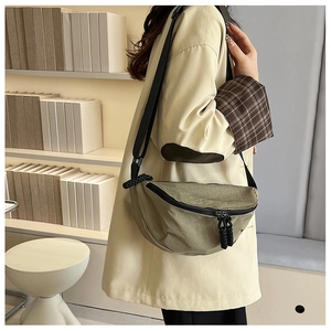 Olive green crescent crossbody bag in wrinkled nylon fabric with knotted rope zippers