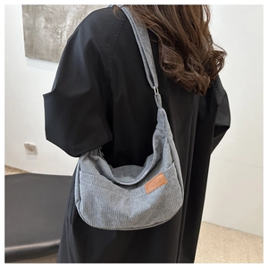 Gray corduroy crescent crossbody bag with adjustable strap and leather fashion label