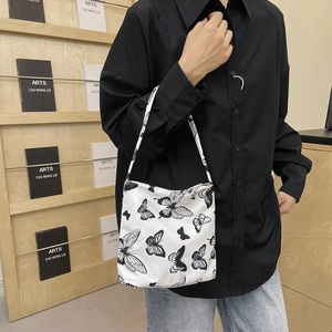 Détail du sac cabas blanc avec motifs papillons noirs et bandoulière confortable