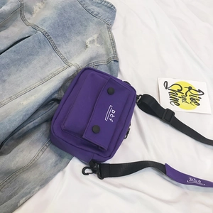 Detailed close-up of a purple canvas crossbody bag with DCY logo on adjustable strap