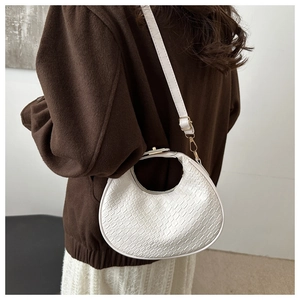 Detail of white hobo bag showing the woven texture and golden metal buckle