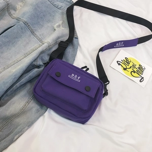 Detail view of purple canvas messenger bag with DCY logo and adjustable shoulder strap