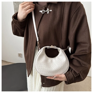 Close-up of white crocodile pattern hobo bag with adjustable strap and metal zipper