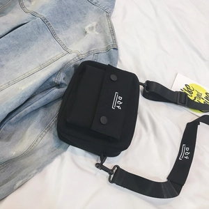Detail of minimalist black canvas crossbody bag with white DCY logo and adjustable strap