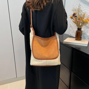 Brown faux suede and cream fleece tote bag styled on shoulder in modern home interior