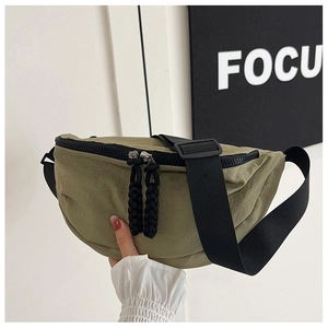 Detail of army green nylon crescent crossbody bag with double zippers and cord pullers