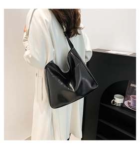 Detail of a black hobo bag in vintage glossy leather with a soft slouchy structure