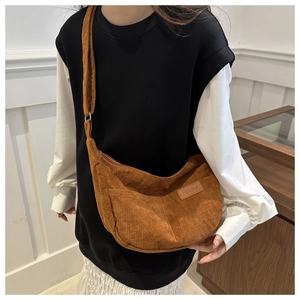 Close-up of brown corduroy crossbody bag texture and fashion leather patch details