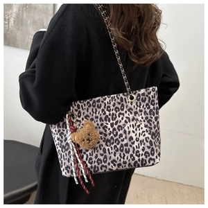 Détail du sac cabas léopard avec bandoulière en chaîne et pendentif ours en peluche