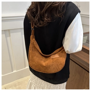 Close-up of caramel corduroy half-moon bag featuring a fashion leather brand label