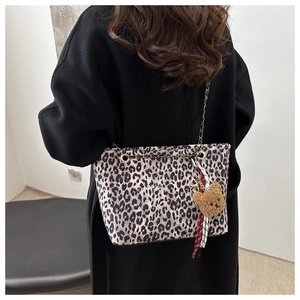 Détail du sac cabas léopard avec bandoulière chaîne et décoration de charme d'ours