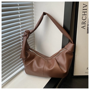 Detailed shot of brown lychee texture leather hobo bag with unique knotted strap detail