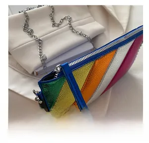 Close-up of smooth silver zipper and metallic rainbow patchwork texture on clutch bag