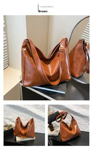 Detail of a large brown vintage tote bag featuring shiny PU leather and golden buckle