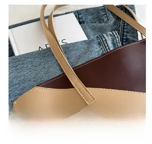 Detail of color-block tote bag showing premium stitching and textured caramel leather