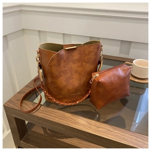 Ensemble sac seau en cuir marron avec texture, poignée tressée et pochette assortie