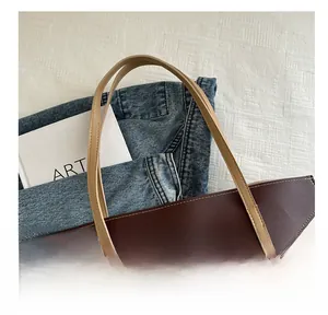 Close-up of the comfortable handle and fine stitching on a two-tone leather tote bag