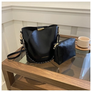 Détail de l'ensemble sac seau en cuir noir avec pochette assortie et ferrures dorées