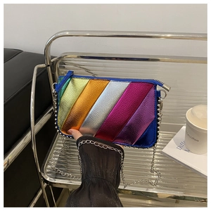 Modern rainbow stripe crossbody bag with silver bead trim on a metal utility cart