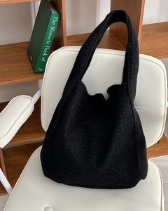 Detailansicht der schwarzen Woll-Tote-Bag mit weicher Textur auf weißem Stuhl
