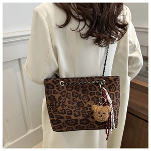 Détail du sac cabas léopard avec chaîne dorée et charmant ourson en peluche marron