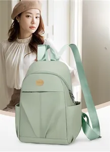 Detail of mint green waterproof nylon backpack with adjustable straps and round logo patch