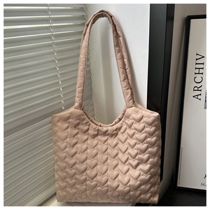 Detailansicht der weichen, gesteppten Nylon-Stofftasche mit Herzmuster in Beige