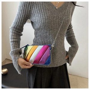 Close-up of rainbow metallic chain bag with diagonal stripes and silver stud details
